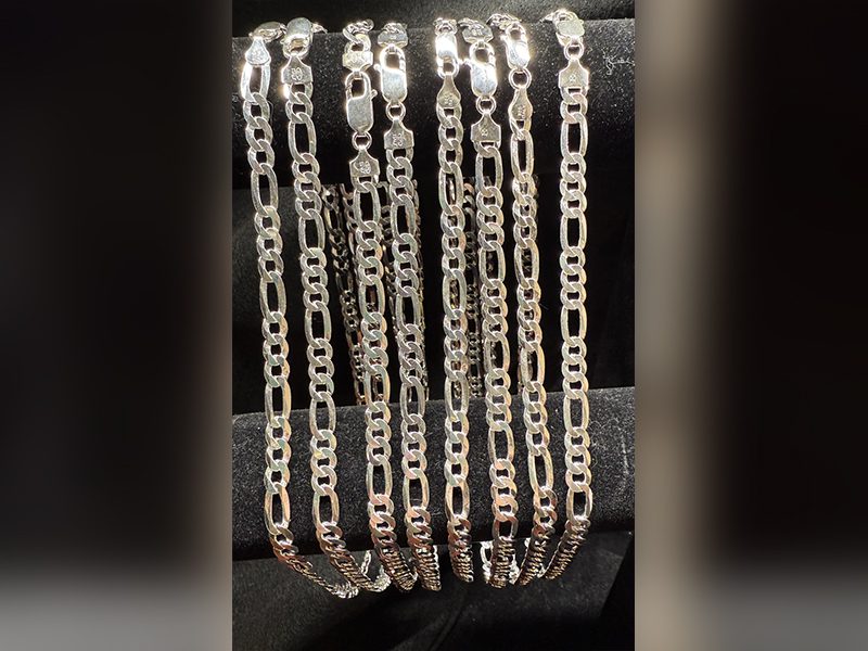 Silver chains displayed on black velvet background.